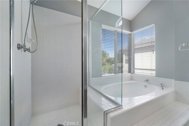 bathroom featuring vaulted ceiling and separate shower and tub