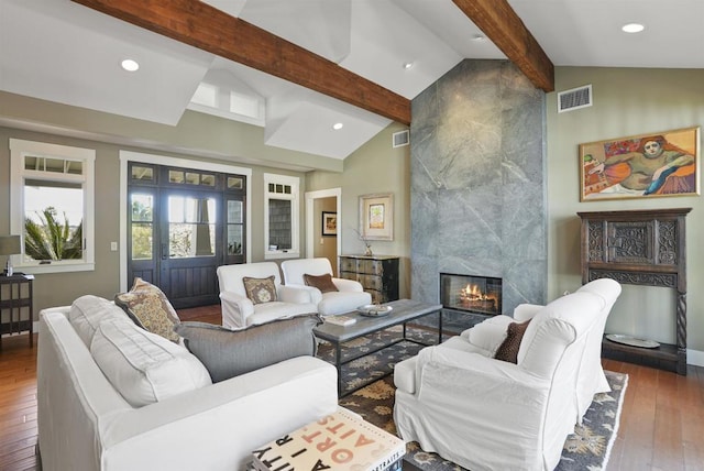 living room with a high end fireplace, lofted ceiling with beams, and dark hardwood / wood-style floors