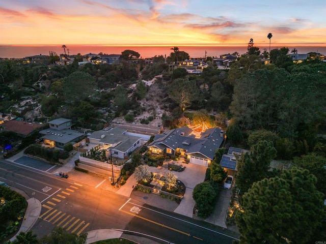 aerial view at dusk featuring a water view