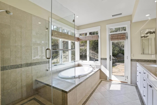 bathroom featuring independent shower and bath, vanity, tile patterned flooring, and tile walls