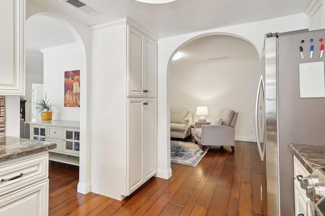 corridor featuring visible vents and dark wood-type flooring