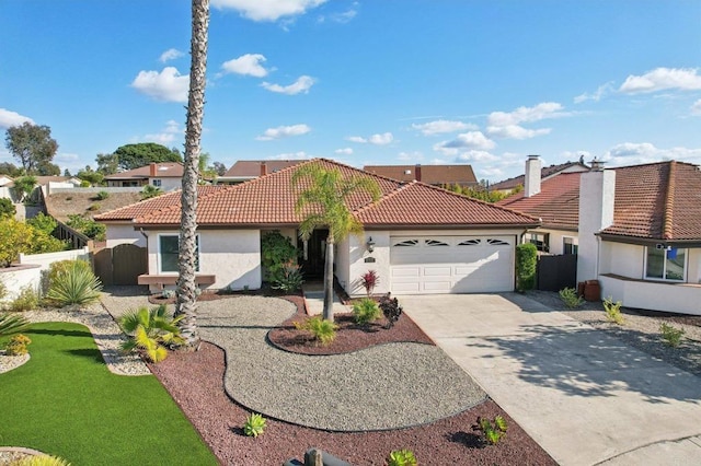 mediterranean / spanish house featuring an attached garage, fence, a tile roof, driveway, and stucco siding