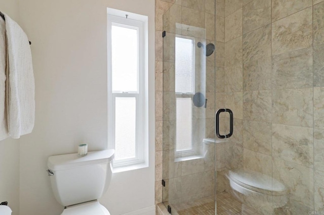 bathroom featuring a stall shower and toilet