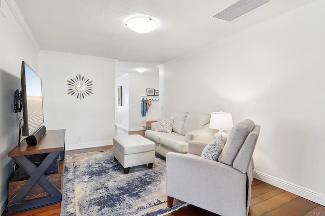 living area featuring visible vents, crown molding, baseboards, and wood finished floors