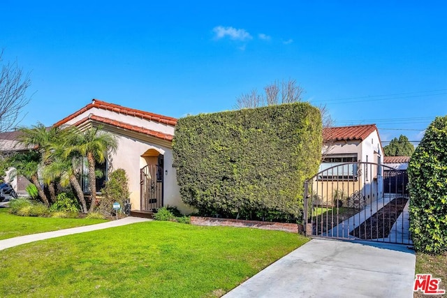 mediterranean / spanish house featuring a front yard