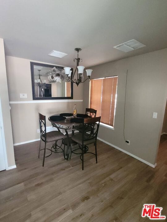 dining area with a chandelier and dark hardwood / wood-style flooring