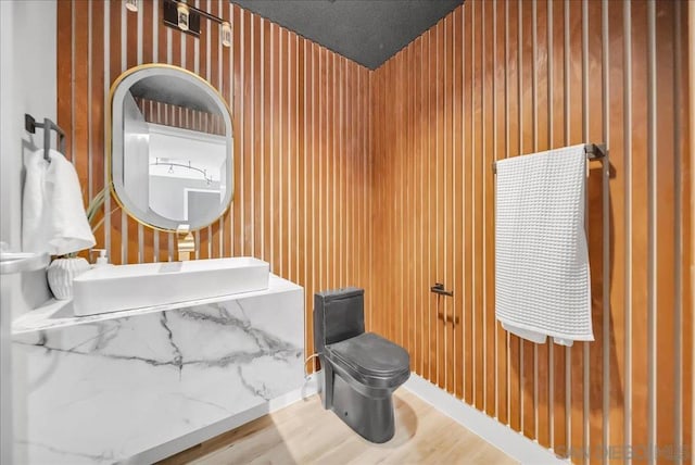 bathroom with wood-type flooring, sink, a textured ceiling, and toilet