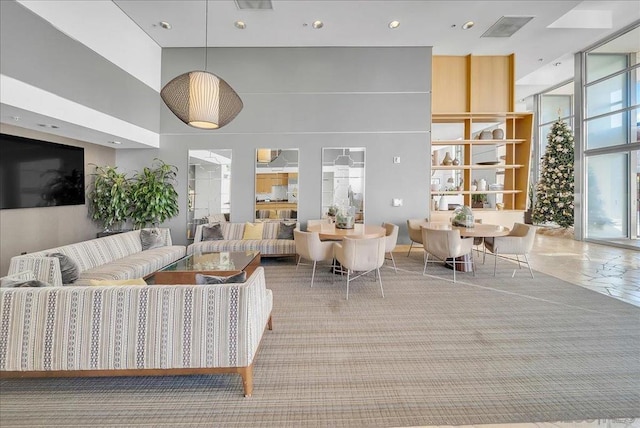 carpeted living room with a high ceiling