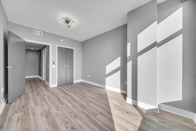 unfurnished bedroom with a closet and light wood-type flooring