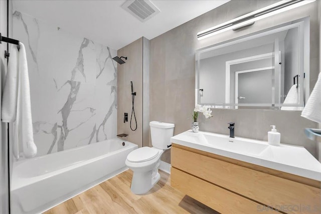 full bathroom with vanity, toilet, hardwood / wood-style floors, and tiled shower / bath