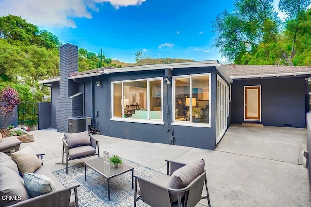 back of house featuring outdoor lounge area, central AC unit, and a patio area