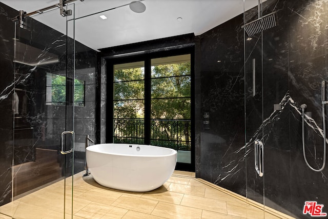 bathroom with tile walls and independent shower and bath