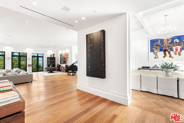 interior space featuring coffered ceiling, light hardwood / wood-style flooring, beamed ceiling, and an inviting chandelier