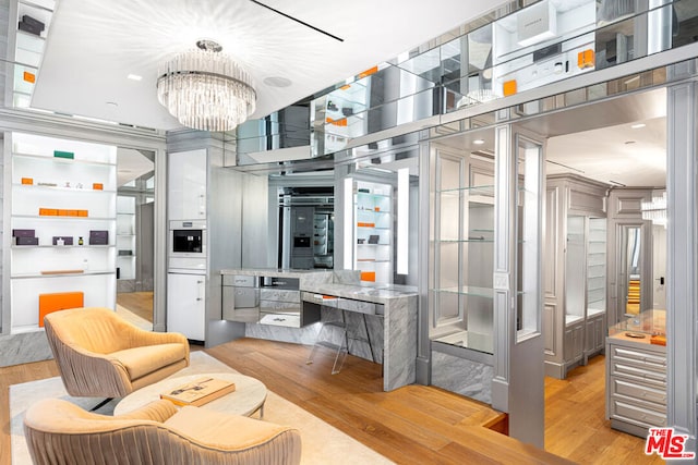 kitchen with a chandelier, light hardwood / wood-style floors, and oven