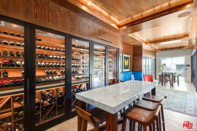 wine cellar featuring wood ceiling, wooden walls, and light tile patterned flooring