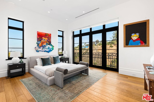 bedroom with light hardwood / wood-style flooring and access to outside