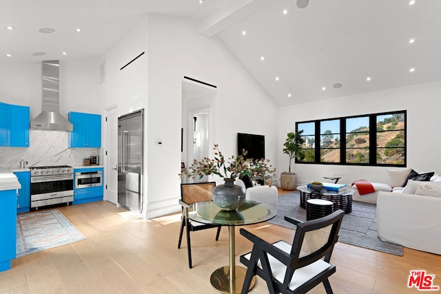 dining space with beam ceiling, light hardwood / wood-style floors, and high vaulted ceiling