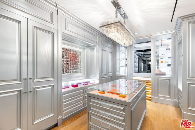 walk in closet featuring a chandelier and light hardwood / wood-style floors