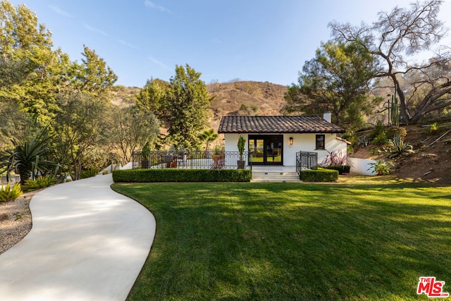 back of house featuring a mountain view and a lawn