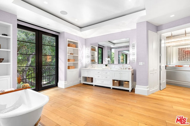 bathroom featuring built in shelves, vanity, a tray ceiling, and hardwood / wood-style flooring