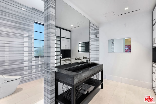 bathroom featuring tile patterned flooring, sink, a shower with door, and toilet