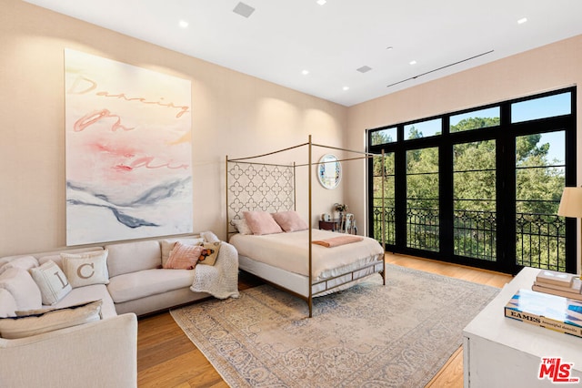 bedroom with access to exterior and light wood-type flooring