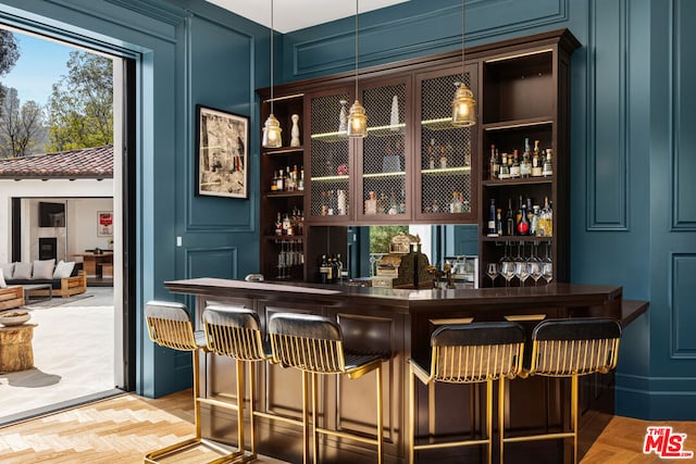 bar featuring pendant lighting and light parquet flooring