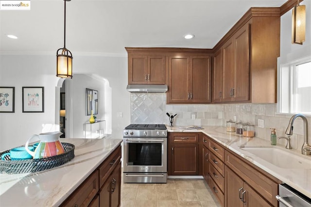 kitchen with pendant lighting, sink, stainless steel appliances, ornamental molding, and light stone countertops