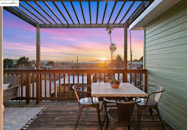 deck at dusk featuring a pergola