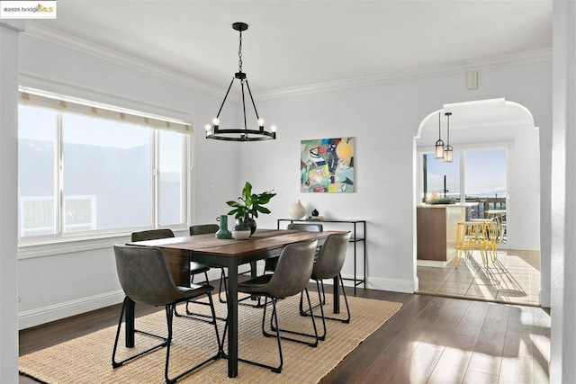 dining area featuring ornamental molding, hardwood / wood-style floors, and an inviting chandelier