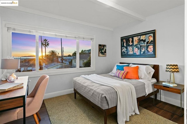 bedroom with dark hardwood / wood-style floors and beamed ceiling