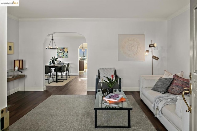 living room featuring crown molding, dark hardwood / wood-style floors, and a chandelier