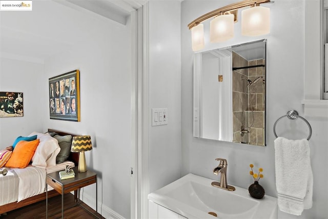 bathroom featuring a tile shower, hardwood / wood-style floors, and vanity