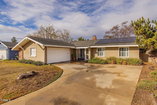 ranch-style house with a garage and solar panels