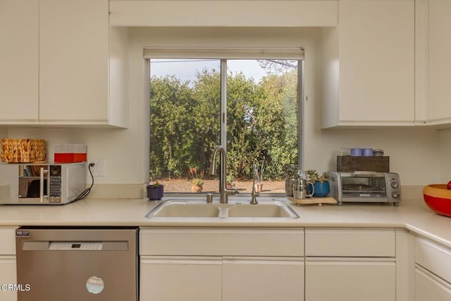 kitchen with white cabinetry, stainless steel dishwasher, and sink