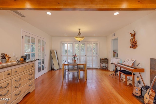 dining room featuring light hardwood / wood-style flooring, beam ceiling, and french doors