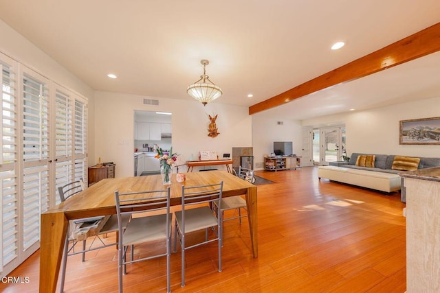 dining area featuring beamed ceiling, light hardwood / wood-style floors, and french doors