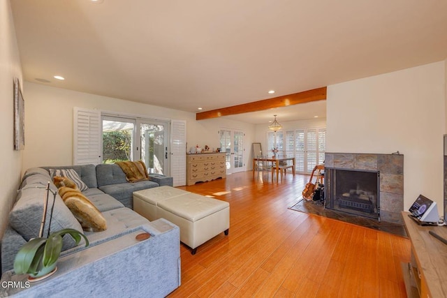 living room with a tile fireplace and light wood-type flooring