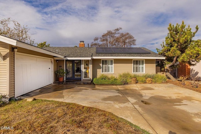 single story home featuring a garage and solar panels