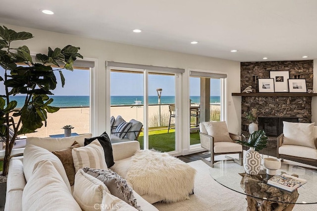 living room featuring a water view, a fireplace, and a view of the beach