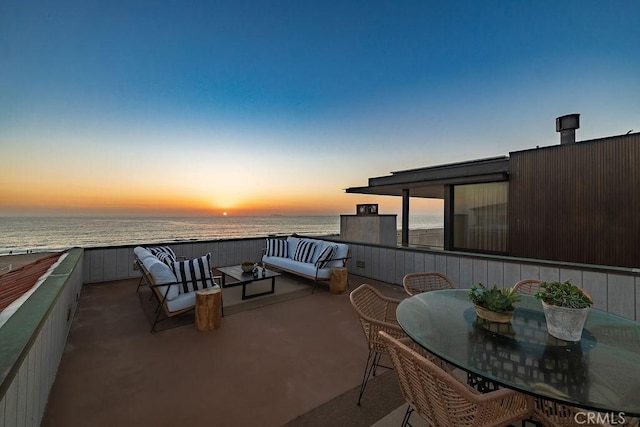 patio terrace at dusk featuring a water view and an outdoor hangout area