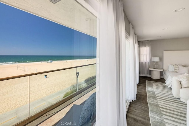 interior space featuring a water view, a view of the beach, and dark hardwood / wood-style flooring