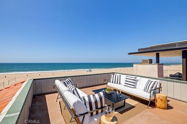 balcony with an outdoor living space, a water view, and a view of the beach