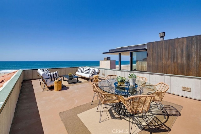 view of patio with a water view, an outdoor hangout area, and a view of the beach