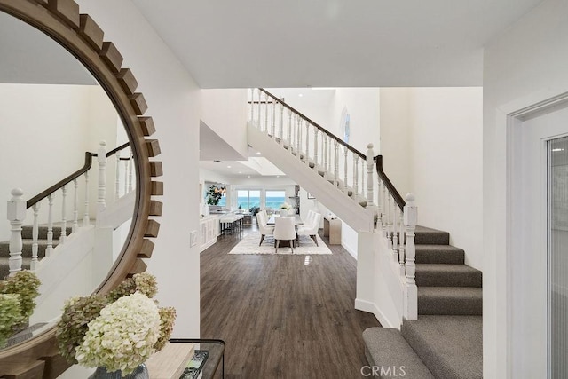 staircase featuring hardwood / wood-style flooring and a high ceiling