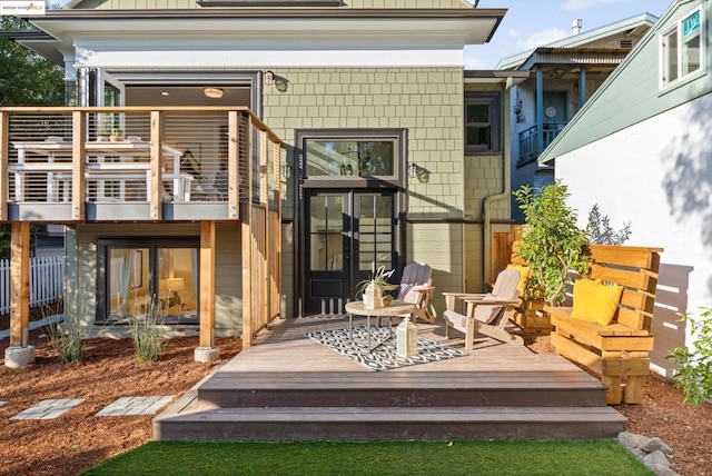 rear view of house featuring a wooden deck and a balcony