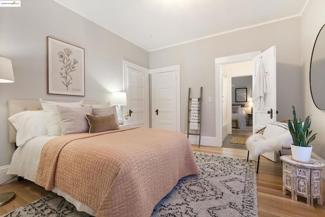 bedroom featuring ornamental molding and light wood-type flooring