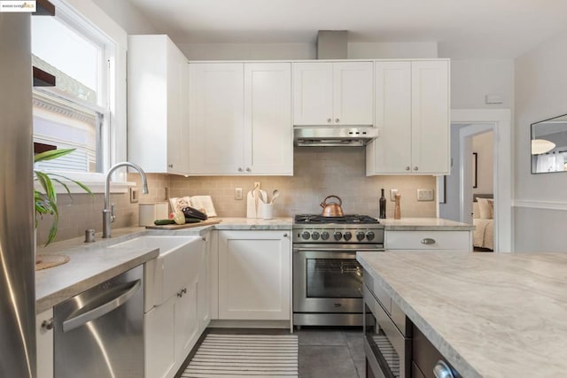 kitchen featuring white cabinetry, sink, backsplash, and appliances with stainless steel finishes