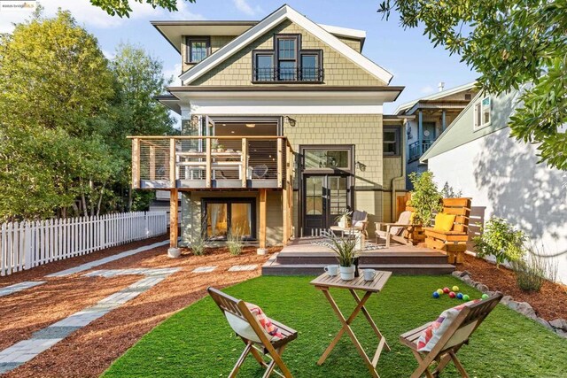 back of property featuring a wooden deck and a yard