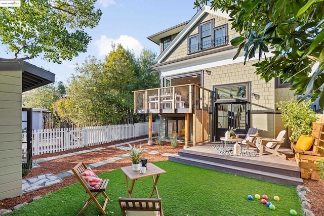 rear view of property with a patio area, a lawn, and a deck